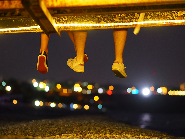 feet dangling from bridge